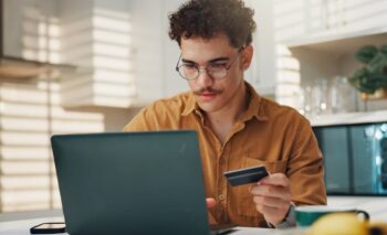 user on laptop with credit card in hand