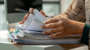 Pile of files being reviewed by a person