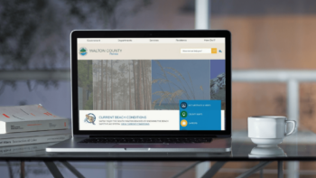 Laptop on a table displaying the Walton County, FL website