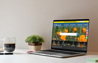 Coffee mug, house plant, and a laptop on a white table