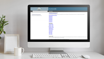 Desktop computer with keyboard and mouse, and a coffee mug on a white desk