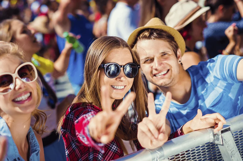 friends smiling and posting for a photo at an outdoor concert